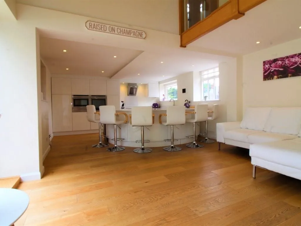 Angela and Francesca's open-plan kitchen with a curved island bar seating six, Harpenden