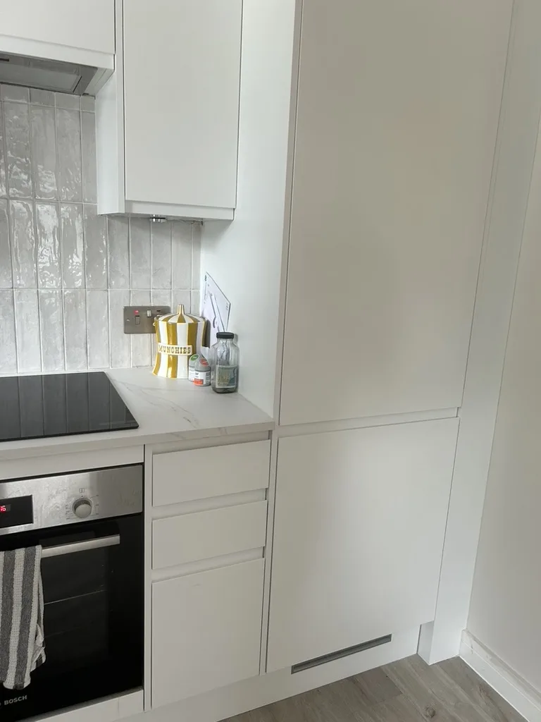 Howdens white matt handleless with a marble-effect worktop and tall housing, Harpenden