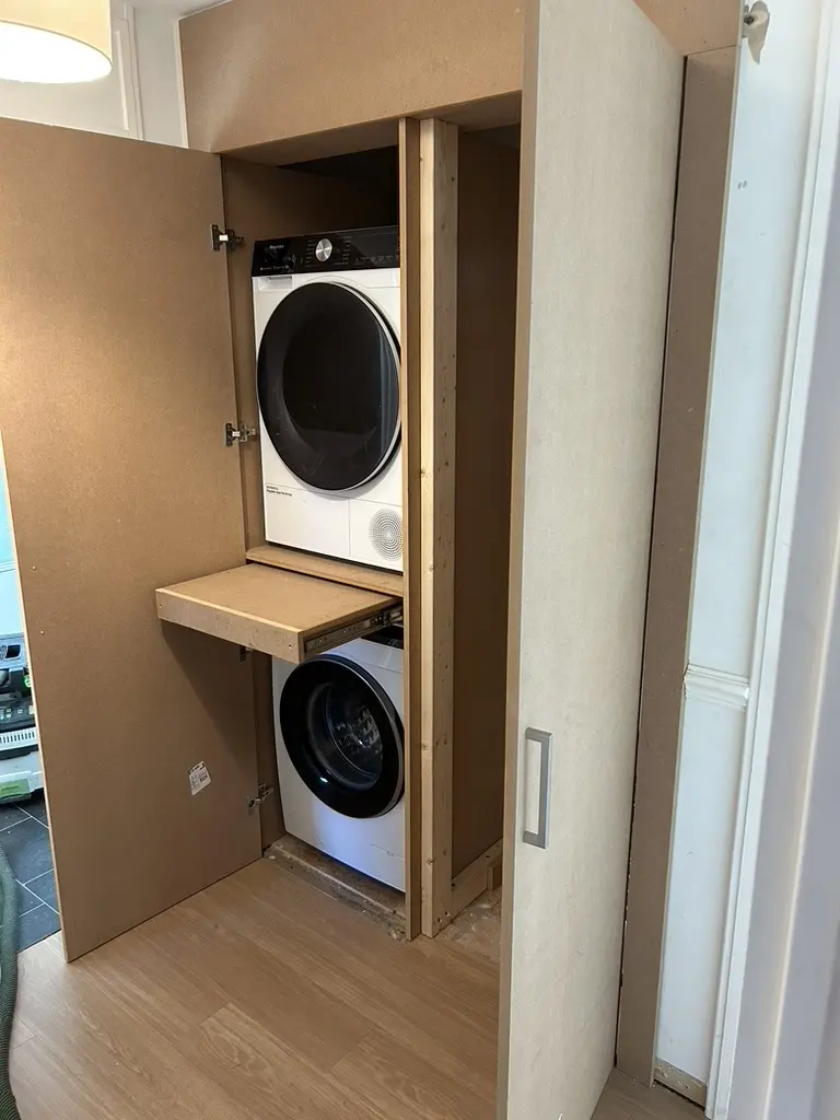 Utility cupboard: stacked washer and dryer with a pull-out shelf, Welwyn Garden City