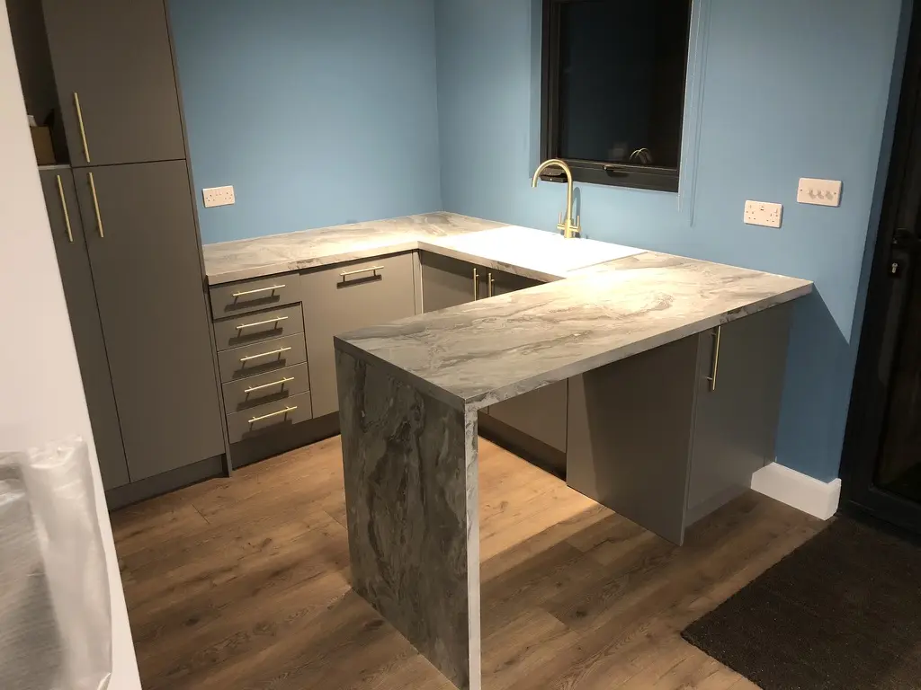 Waterfall-edge peninsula with grey units and brass handles, St Albans