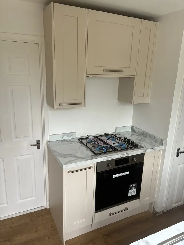 Cream shaker hob and oven run with marble-effect worktop