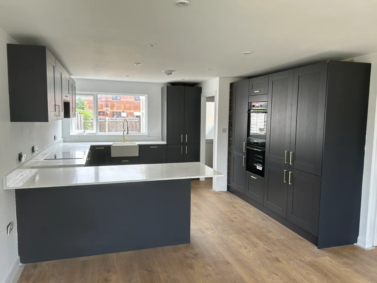 Charcoal shaker kitchen with peninsula and tall oven housing