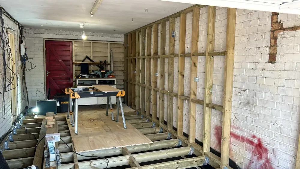 Garage conversion in progress: new stud wall and floor
